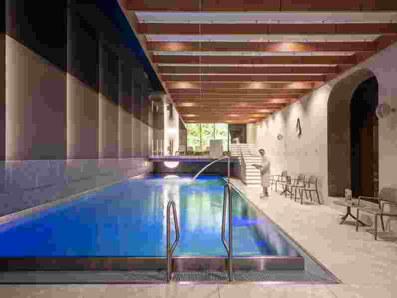Pool area in spa with free-hanging acoustic baffles with wood appearance and acoustic wall panels in fabric