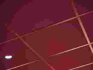 Close-up of dark red suspended acoustic ceiling with matching grids