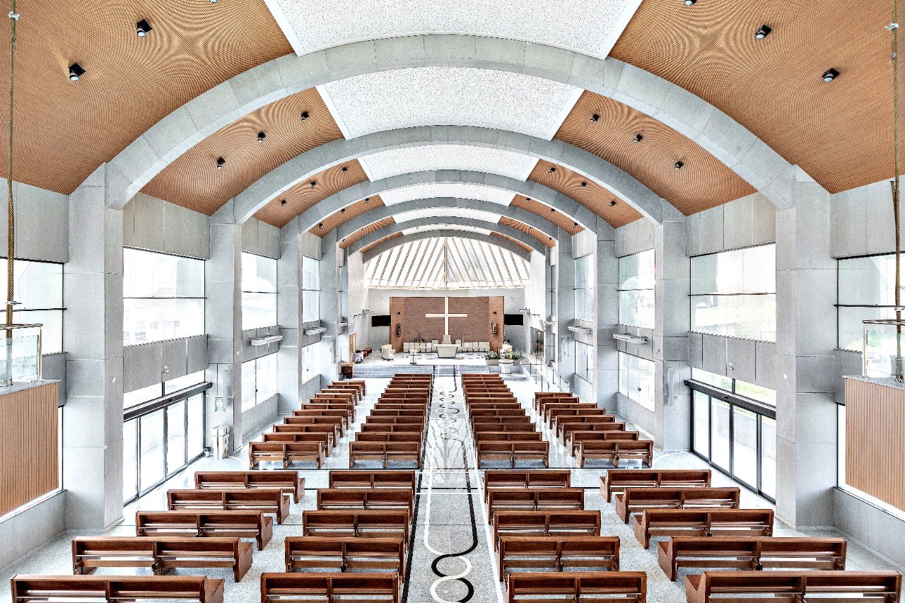 Sistema acústico Nexacustic instalado em igreja com estrutura em arco e forro Ecophon