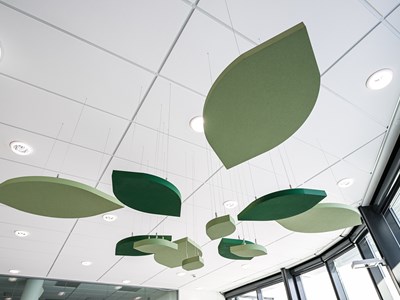 Green, leaf-shaped free-hanging acoustic panels in office